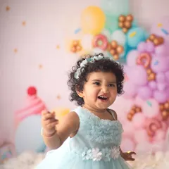 Oh, that sweet, cheeky grin just makes my day. This little doll absolutely rocked her donut-themed cake smash session, and her personality shines through in every shot.
