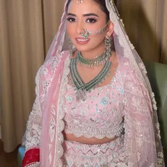 A close-up of this modern bride's look. The focus is on fresh, dewy skin, soft pink eyeshadow, and a delicate nose ring that adds a touch of tradition to her contemporary style.