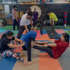 I am always there to provide hands-on assistance and ensure your alignment is correct and safe. In this partner stretch, I am helping a student get a deeper, more effective stretch in their hamstrings.