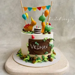 A roarsome party with friendly dinosaurs! This cake features cute, hand-sculpted dinosaurs celebrating with party hats and balloons. It’s a fun and playful design perfect for a little one's birthday.