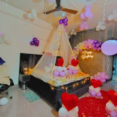 Another angle of the romantic room decoration, showing the full bed canopy and balloon arrangement.