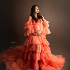 Capturing the pure joy of motherhood. This beautiful mom-to-be is glowing in a voluminous, layered orange gown that makes a bold statement.