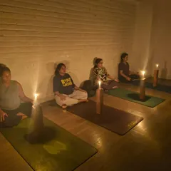 A group of expecting mothers immersed in Tratak meditation. The gentle glow of the candles creates a tranquil atmosphere, perfect for cultivating the focus and inner peace needed during pregnancy.