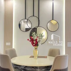 A closer look at the elegant dining setup with a round marble-top table and comfortable upholstered chairs. The decorative wall mirrors and vertical panels create a beautiful, minimalist focal point.
