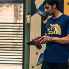 Getting the right gear is your first step. An instructor explains the importance of proper climbing shoes, which are crucial for grip and effective footwork on the bouldering wall.