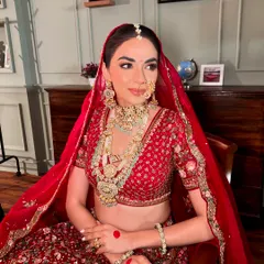 The complete traditional red bridal ensemble. Every detail, from the makeup to the jewellery, comes together to create a look of pure elegance.