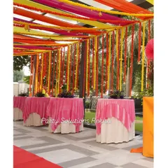 Another view of the colorful draped ceiling and marigold curtain, showing how it creates a cohesive and celebratory atmosphere throughout the entire venue. The pink table overlays tie the whole look together.