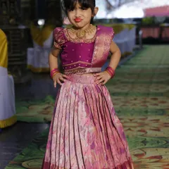 This little one is striking a pose in her custom-made langa voni, perfectly matching her mother's outfit.