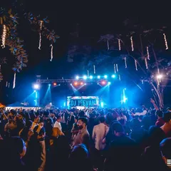 The stage setup and crowd at The Lalit Bangalore, with my name lighting up the background. I am experienced in working with large event production teams to ensure perfect sound and visuals.