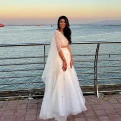An ethereal look by the sea. This client's white lehenga was paired with a soft, glowing makeup look and long, flowing waves, creating a dreamy and romantic style for an evening event.