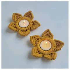 A top-down view of the mustard-colored tealight holders, showing the neat, star-shaped knot work.