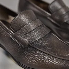 A closer look at the craftsmanship of the dark brown leather loafers, highlighting the detailed stitching and the supple, high-quality texture of the leather.