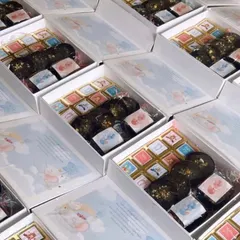 A look at a bulk order of baby announcement hampers for twins. These boxes are filled with custom-printed chocolates and other treats to share the joyous news.