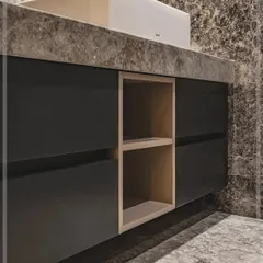 A detail shot of the floating vanity unit, showing the handleless drawers and an open-shelf niche. The design is clean and modern, providing a warm contrast to the dark, dramatic wall finish.