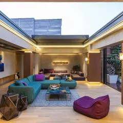 This vibrant lounge in a New Delhi residence is an entertainment area designed for soulful moments. We used eclectic Paola Lenti furniture against concrete and rust-finished walls, with a retractable roof for a seamless connection to the outdoors.