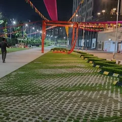 This is a wide shot of an outdoor entrance structure being set up at dusk. The frame is ready for final lighting and shows the scale of the decoration in a large open ground.
