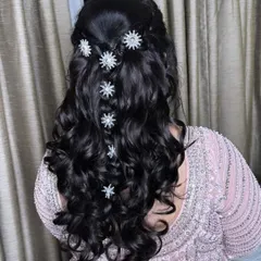 Stars in her hair. This beautiful open-curl hairstyle is decorated with star-shaped clips, adding a touch of whimsy and sparkle for a sangeet or reception.