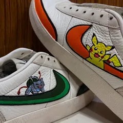 A close-up look at the detailed artwork on the custom sneakers. You can see the clean lines and vibrant colors used for Pikachu and Bulbasaur, painted to last on the leather surface.