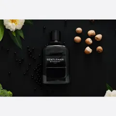 A classic commercial product shot for a men's fragrance, styled with its core scent ingredients. This type of clean, descriptive photography is essential for e-commerce sites and print advertisements.