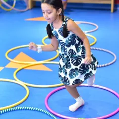 Hopping through hoops is a fun challenge in our active camps. I use colorful equipment to create engaging obstacle courses that help develop balance and gross motor skills in a playful setting.