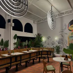 The interior of a rooftop cafe we recently landscaped. The combination of large potted plants, wall murals, and modern furniture creates a curated and elevated ambiance that is both stylish and serene.
