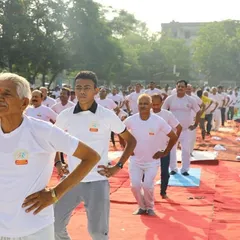 Participants engaged in a warm-up exercise during a large public yoga session. It is inspiring to see people of all ages and backgrounds coming together to take care of their health.