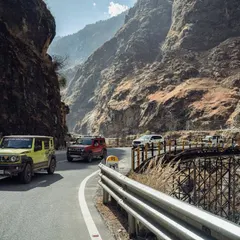 A series of images showing a convoy of 4x4 SUVs navigating the winding, mountainous roads of Spiti. These shots highlight the challenging yet rewarding nature of the expedition.