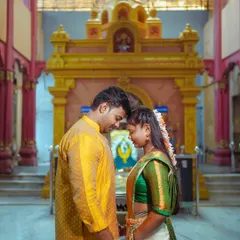 A South Indian couple shares an intimate moment inside a temple, their foreheads touching in a gesture of love and reverence.