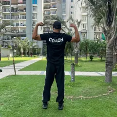 The back of my shirt says it all. I am a coach dedicated to my athletes, pictured here in an outdoor training setting.