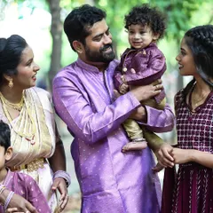 A candid family portrait taken outdoors. I love capturing the natural interactions between parents and their children in a relaxed setting.