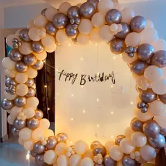 This front-on shot highlights the beautiful color combination of the cream and silver balloons in this birthday arch decoration.
