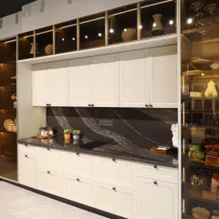 This angled view highlights the clean lines and thoughtful layout of this modular kitchen. The dark countertops provide a beautiful contrast to the off-white cabinets, and the simple, elegant hardware completes the classic yet modern aesthetic.