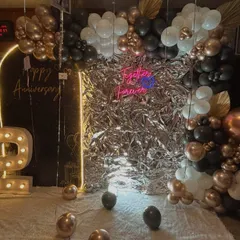 We designed this chic and modern anniversary setup featuring a striking silver foil backdrop. The marquee number '2' and a mix of black, white, and rose gold balloons add a touch of sophisticated fun.