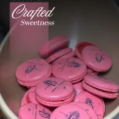 Custom-crafted sweetness. These vibrant pink macarons are branded with a custom logo, showcasing our ability to personalize desserts to match your event's theme or branding.