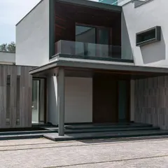 The entrance porch at Rosewood Farmhouse is marked by a large canopy that provides shelter and adds architectural drama. The steps leading up to the entrance create a sense of elevation and formality, setting the stage for the home within.