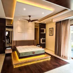 This master bedroom is a sanctuary of modern comfort, centered around a custom floating platform bed with warm LED under-lighting. I used a combination of dark wood flooring, a multi-layered false ceiling with cove lighting, and a minimalist white panelled accent wall to create a sophisticated and restful atmosphere.