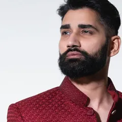 A profile view showcasing the sharp cut and structured shoulder of our crimson bandhgala. Every detail is considered to create a garment that is both comfortable and visually striking.