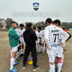 A coach huddles with his team, teaching the importance of teamwork, resilience, and passion. Our coaches are mentors on and off the pitch.