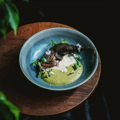 A dish that tells a story of heritage and craft. This is our Kadaknath confit leg, artfully plated with a vibrant green puree and delicate edible flowers. It represents our philosophy of transforming carefully sourced ingredients into culinary art.