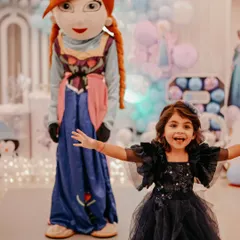 The birthday girl poses with an Anna mascot at her Frozen-themed party. We can arrange for character mascots to visit your event, creating priceless memories and interactions for the children.