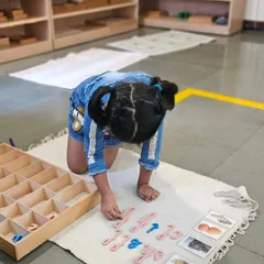 Language development is a cornerstone of our curriculum. Using the movable alphabet, this child is forming words and exploring phonetics, transforming the abstract concept of letters into a tangible, engaging activity that builds a strong foundation for reading and writing.