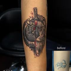 This is a great example of a complete tattoo transformation. We covered an old, unwanted design with a powerful custom piece featuring a lion, a broken clock, and a sword. The detailed black and grey shading ensures the old tattoo is gone for good.