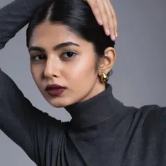 A bold and modern look featuring a deep, matte burgundy lip. The skin is kept clean and the hair is styled in a sleek low bun to keep all the focus on the powerful lip color.