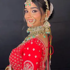A beautiful close-up of a bride in a red lehenga, highlighting the stunning bridal jewelry, including the nath and choker necklace.