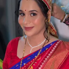 A close-up portrait highlighting the soft eye makeup, rosy cheeks, and the traditional Dejhoor earrings.