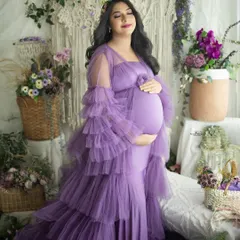 A serene solo portrait of a mother-to-be in a dreamy lavender gown. The floral crown and our lush boho setup create a whimsical and romantic atmosphere.