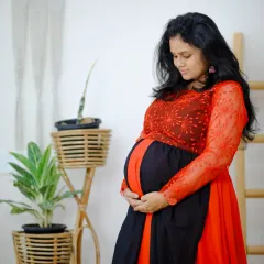 I love capturing these quiet, beautiful moments. This comfortable red and black maternity gown features delicate embroidery on the sleeves, adding a touch of elegance to your special photoshoot.