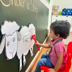 Shearing season is here. A little farmer carefully 'shears' the wool off our pretend sheep, a fun, tactile activity during our Farm Week that teaches about animals and their uses.