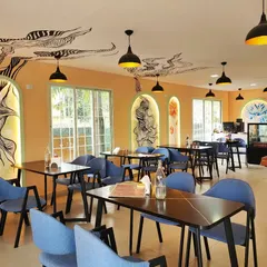 An overview of the main dining area at Essence Cafe in Kolar. We designed multiple art features, including abstract line art that travels across the ceiling, to create a cohesive and dynamic environment.