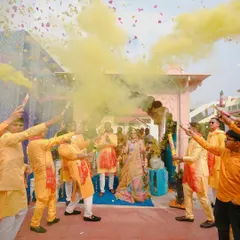 A grand entrance for the Haldi ceremony, with the couple being welcomed by friends and family with yellow smoke bombs. This photo captures the high energy and celebratory start to the event.